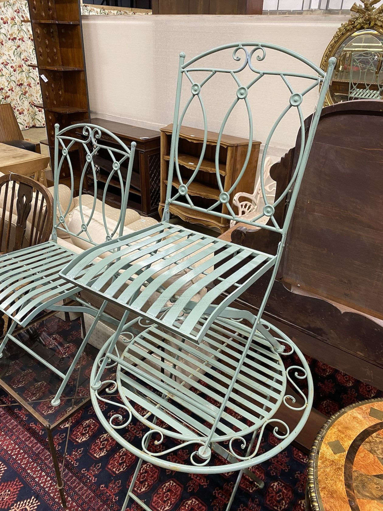 A circular painted metal folding garden table, diameter 70cm, height 76cm and two chairs